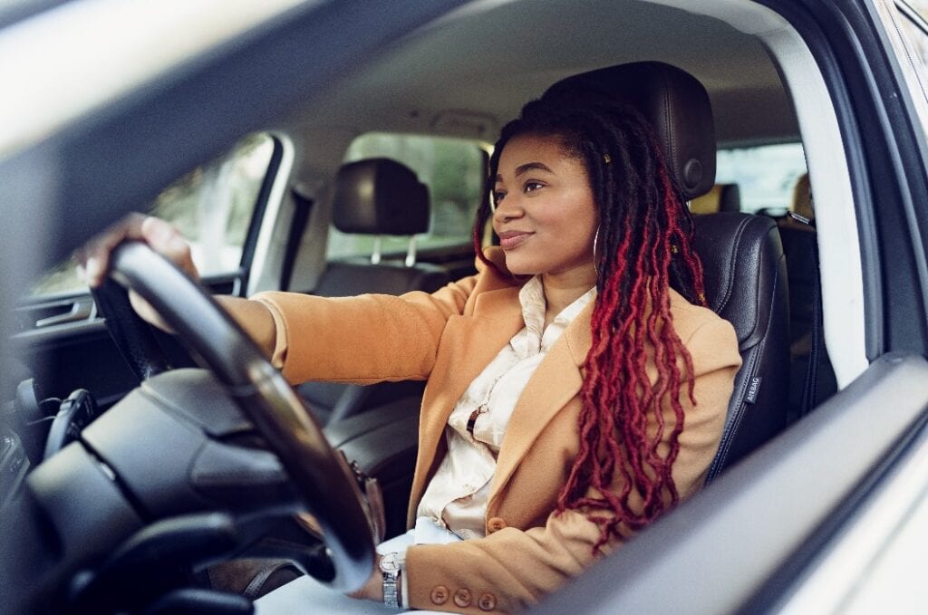 Portrait of positive african american lady inside the car